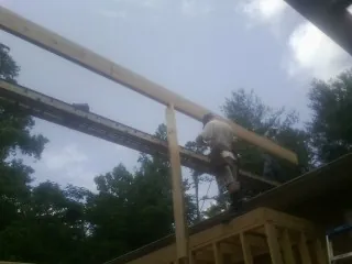 Carpenter setting a ridge beam over a new addition frame — Ice Dam Removal by Roofing Brothers in Pillager
