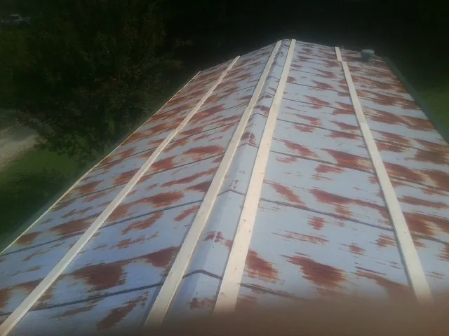 Rusted metal roof panels with new wood purlins before replacement — Storm Damage Roof Repair in Pillager by Roofing Brothers