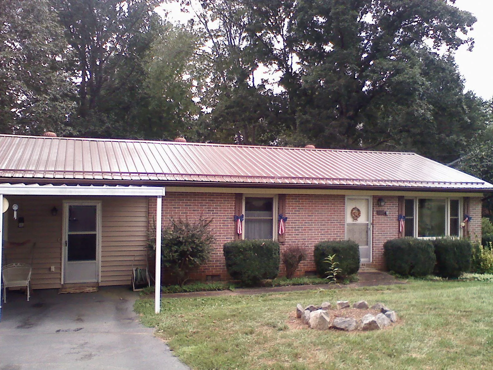 Bronze metal roof and carport on a brick ranch home — Roof Repair work by our crew in Pillager